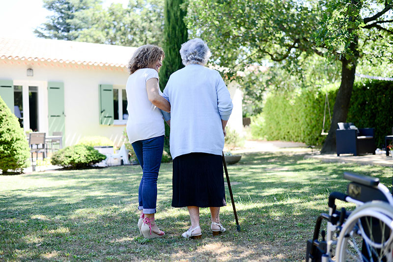 Cheerful mature woman walking with an elderly senior female
